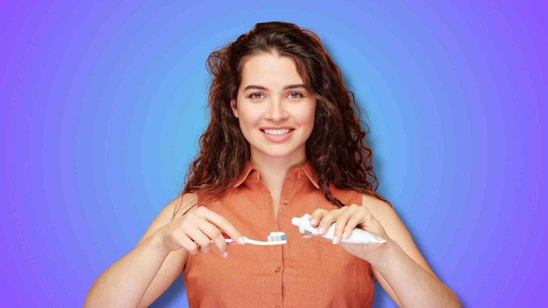 A woman holding toothpaste and toothbrush