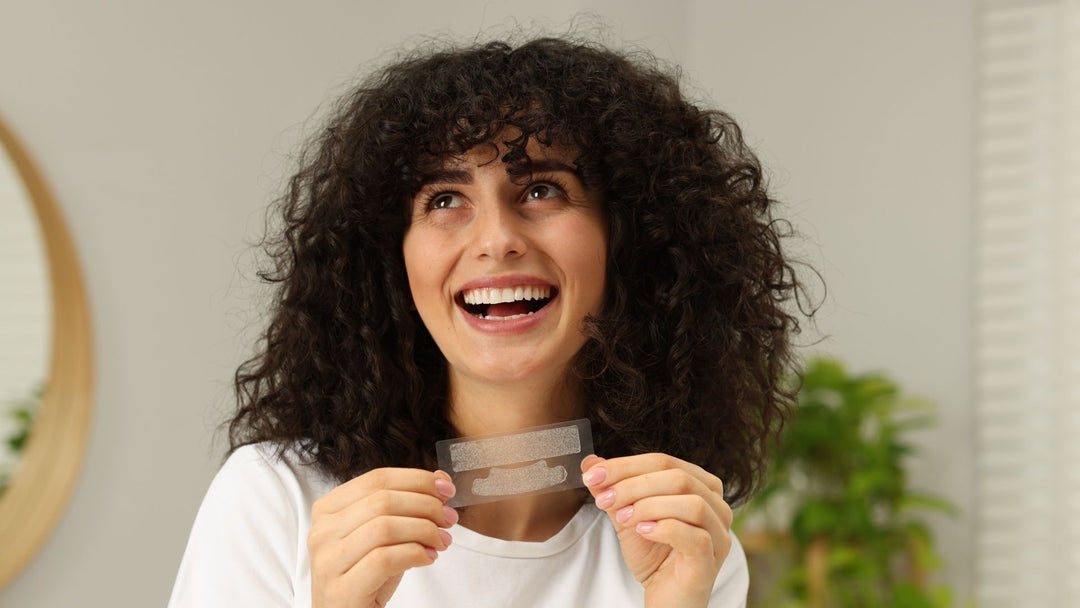 A woman holding whitening strips