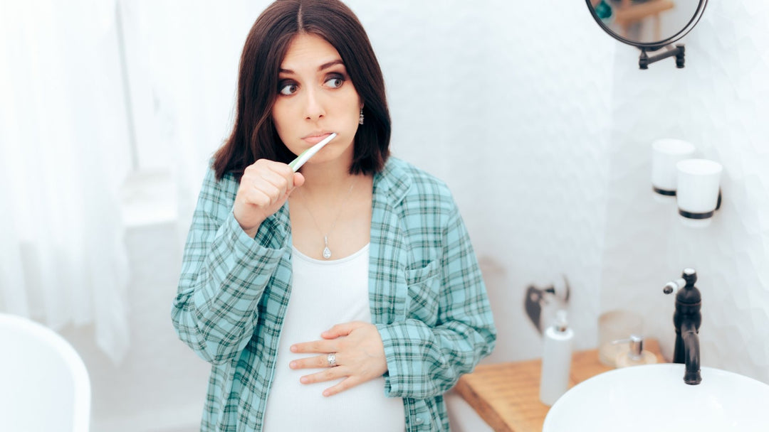 a pregnant woman brushing her teeth